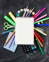 Foto gratuita efectos de escritorio coloridos, pinturas, calculadora debajo del cuaderno en fondo gris