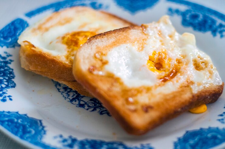 Eggy pan en el plato, fotografiado con luz natural. Golden tostadas francesas con mantequilla y huevo. Desayuno con pan. Desayuno inglés. Desayuno saludable con huevos. Sabroso desayuno