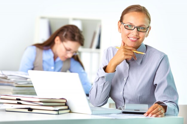 Ejecutiva con gafas en su lugar de trabajo