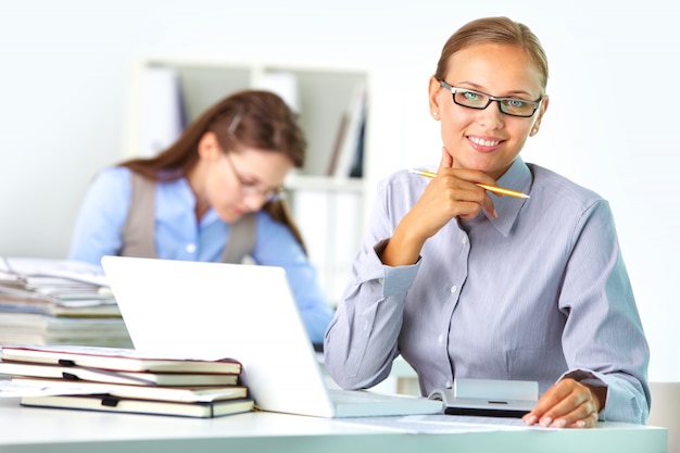 Ejecutiva con gafas en su lugar de trabajo