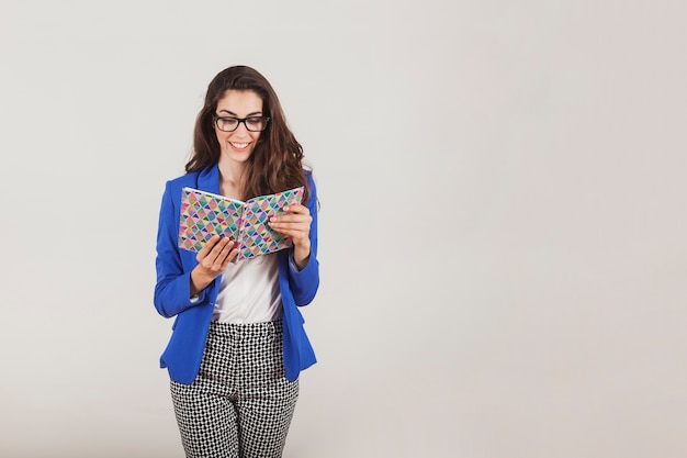 Foto gratuita ejecutiva guapa con chaqueta azul leyendo un libro