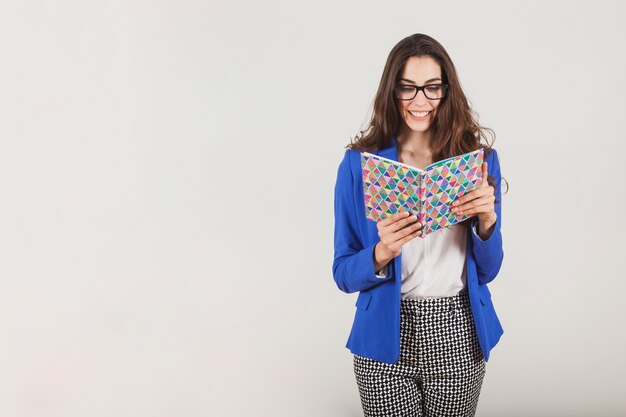 Ejecutiva joven sonriendo y leyendo un cuaderno