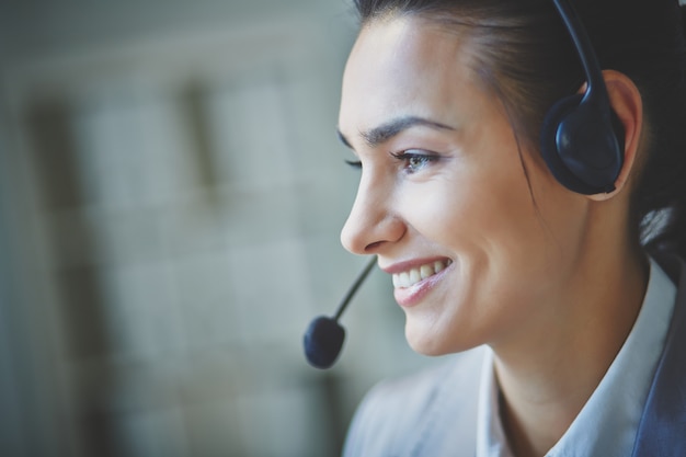 Ejecutiva sonriente usando unos auriculares