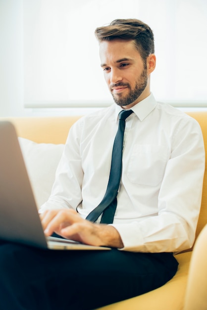 Foto gratuita ejecutivo joven trabajando con su portátil