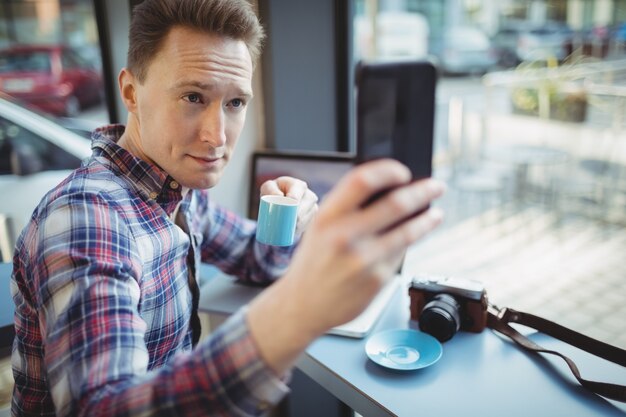 Ejecutivo masculino tomando selfie desde teléfono móvil