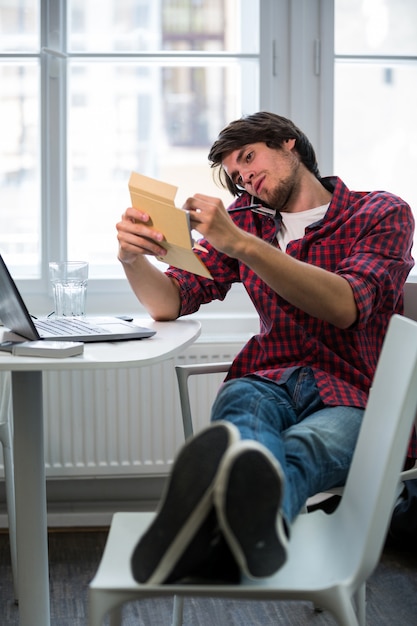 Foto gratuita ejecutivo de negocios masculino que escribe en la libreta mientras se habla por teléfono móvil