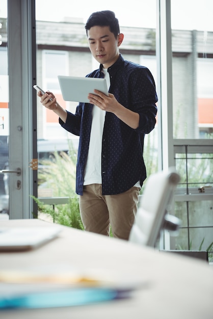 Ejecutivo de negocios con teléfono móvil y tableta digital