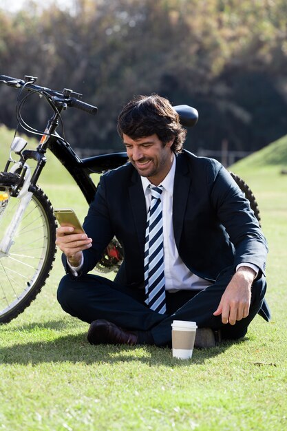 Ejecutivo sonriente controlando su teléfono móvil