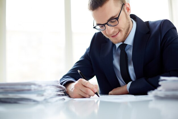 Ejecutivo sonriente escribiendo una nota