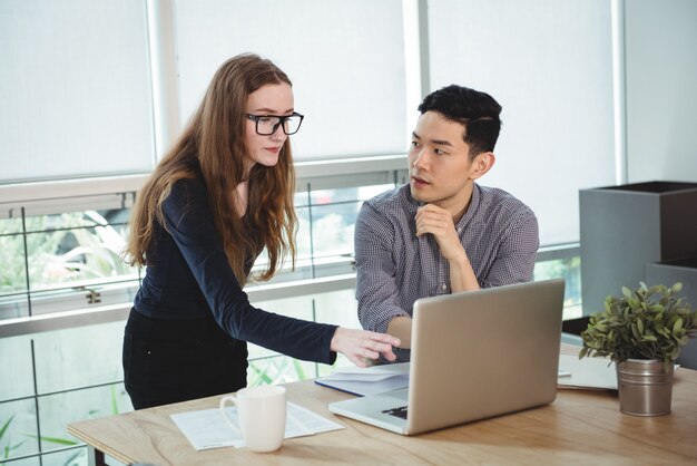 Ejecutivos de negocios discutiendo sobre laptop