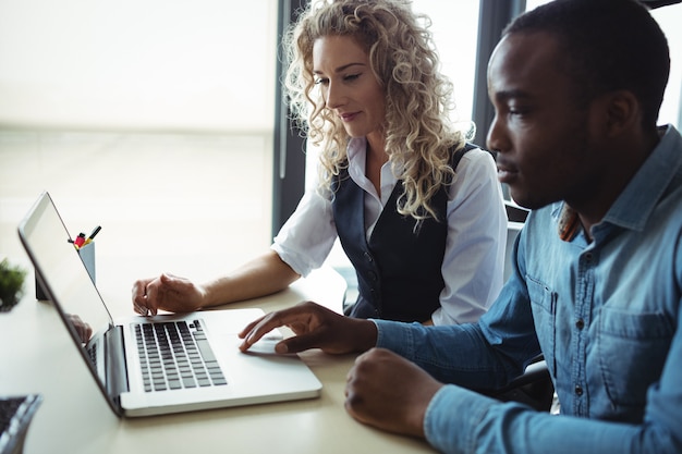 Ejecutivos de negocios discutiendo sobre laptop