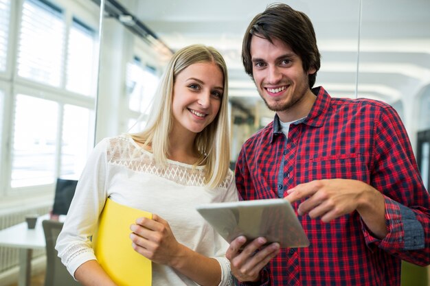 ejecutivos de negocios masculinos y femeninos que usa la tableta digital de