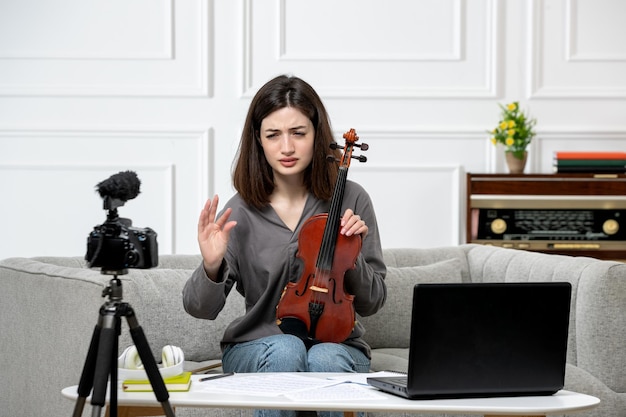 Foto gratuita elearning dando clases de violín de forma remota en casa joven linda hermosa niña confundida