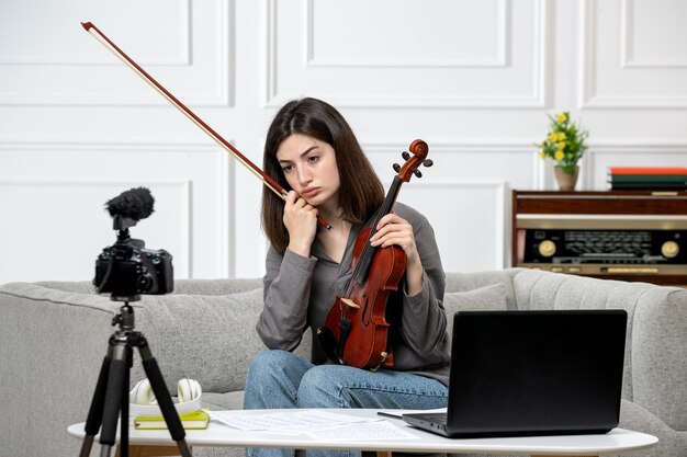 Foto gratuita elearning dando clases de violín de forma remota en casa joven linda hermosa niña grabando video