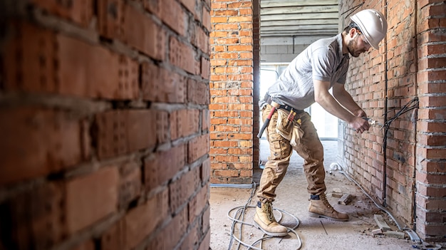 Un electricista de la construcción corta un cable de voltaje durante una reparación