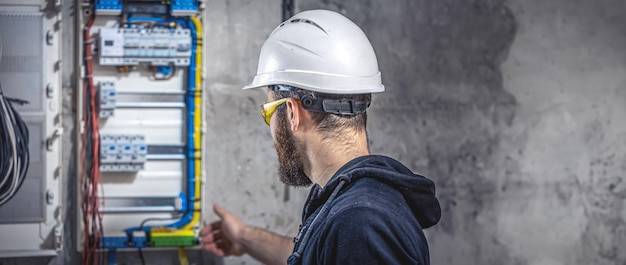 Foto gratuita un electricista trabaja en una central eléctrica con un cable de conexión eléctrica