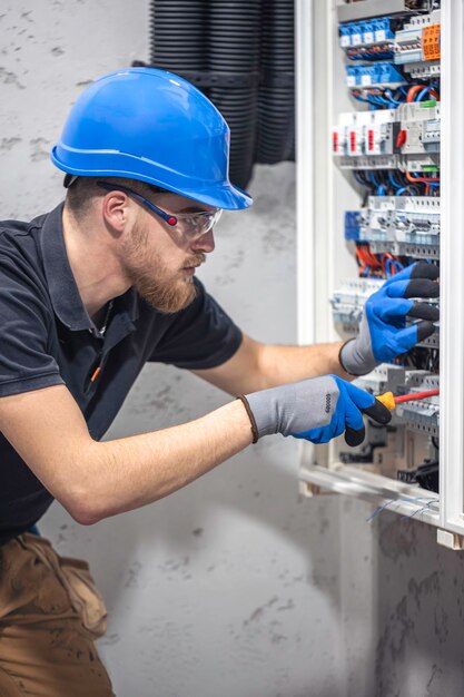 Foto gratuita un electricista trabaja en una central eléctrica con un cable de conexión eléctrica