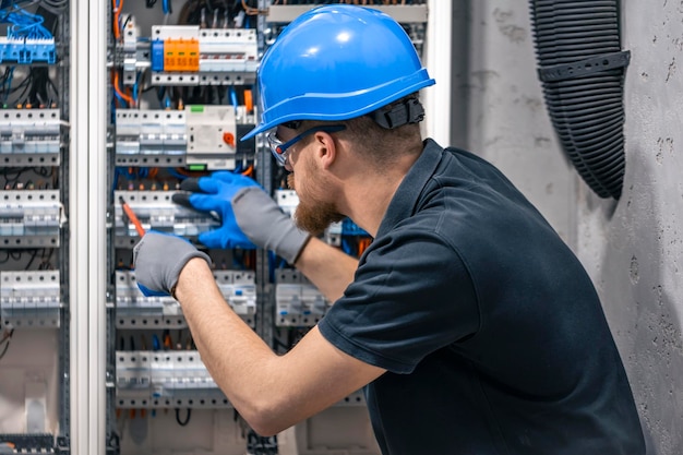 Foto gratuita un electricista trabaja en una central eléctrica con un cable de conexión eléctrica