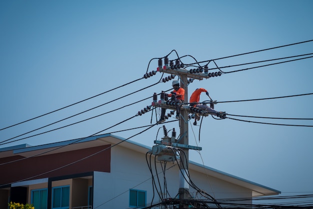 Los electricistas se suben a postes eléctricos para instalar y reparar líneas eléctricas.
