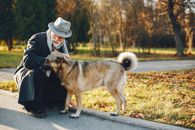 Elegante anciano en un parque soleado de otoño