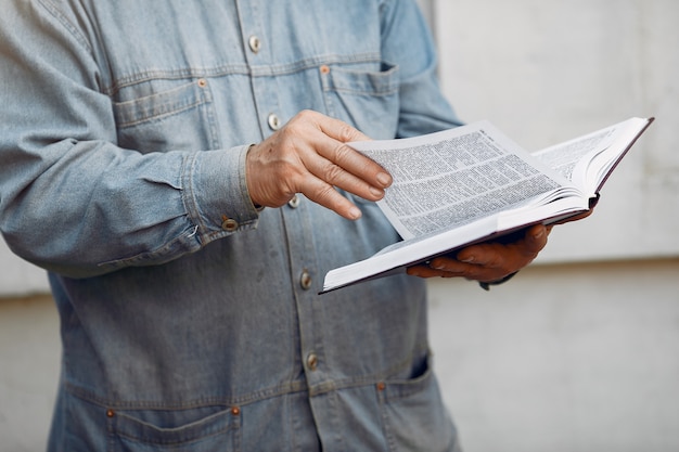 Elegante anciano de pie con un libro