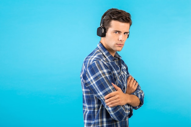 Elegante atractivo joven guapo escuchando música con auriculares inalámbricos