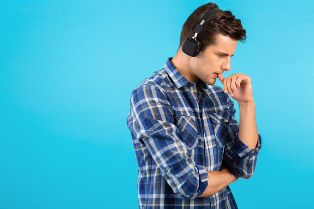 Elegante atractivo joven guapo escuchando música con auriculares inalámbricos