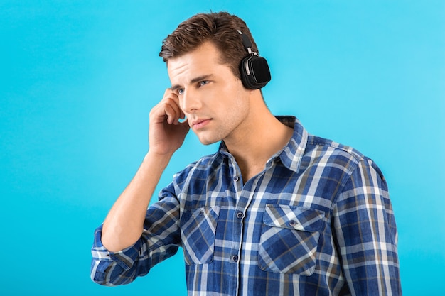Elegante atractivo joven guapo escuchando música con auriculares inalámbricos