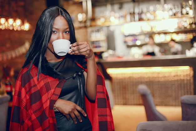 Elegante chica negra en un cafe