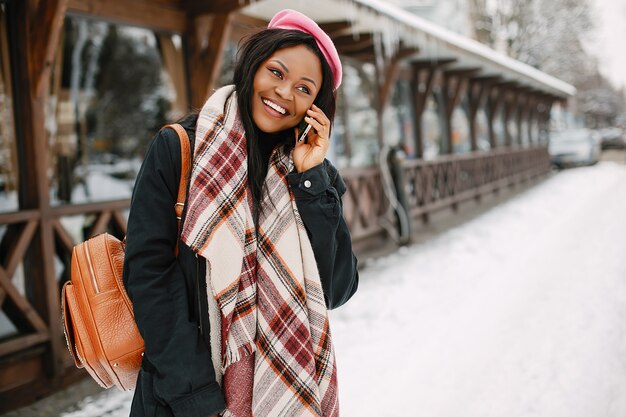 Elegante chica negra en una ciudad de invierno.