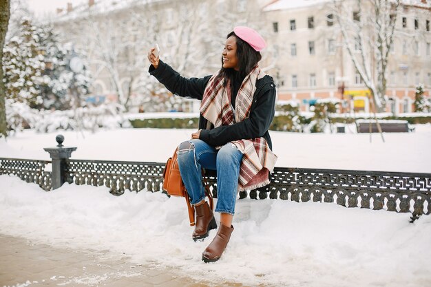 Elegante chica negra en una ciudad de invierno.