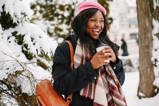 Elegante chica negra en una ciudad de invierno.