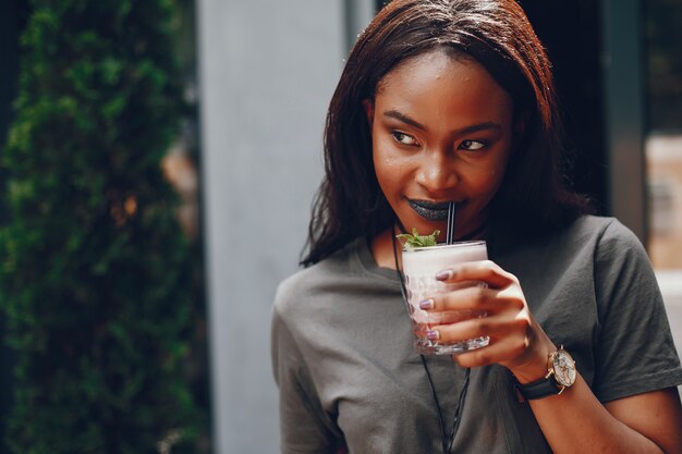 Elegante chica negra en una ciudad de verano.