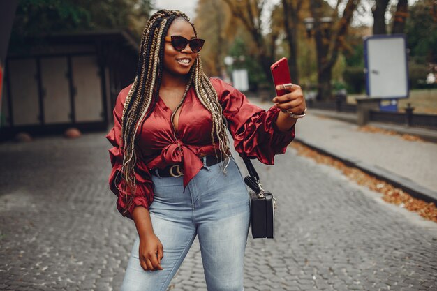 Elegante chica negra en una ciudad de verano.