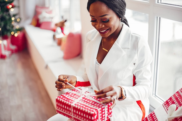 elegante chica negra en una habitación en Navidad