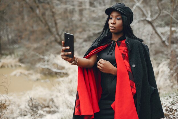 Elegante chica negra en un parque de invierno