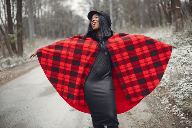 Elegante chica negra en un parque de invierno