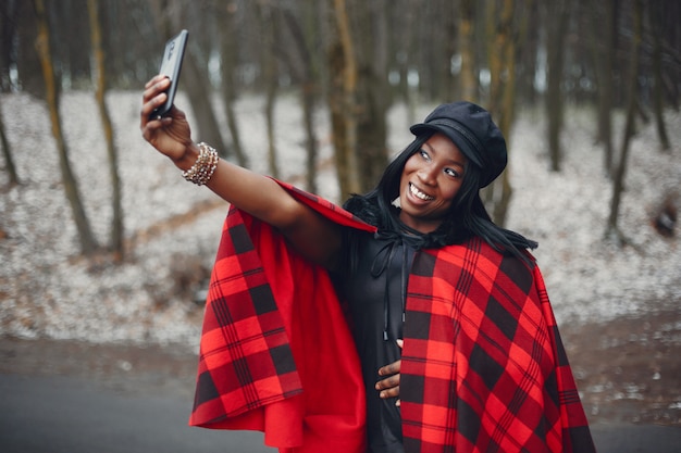 Elegante chica negra en un parque de invierno