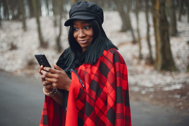 Elegante chica negra en un parque de invierno