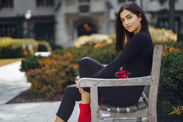 elegante chica sentada en un banco en la escuela