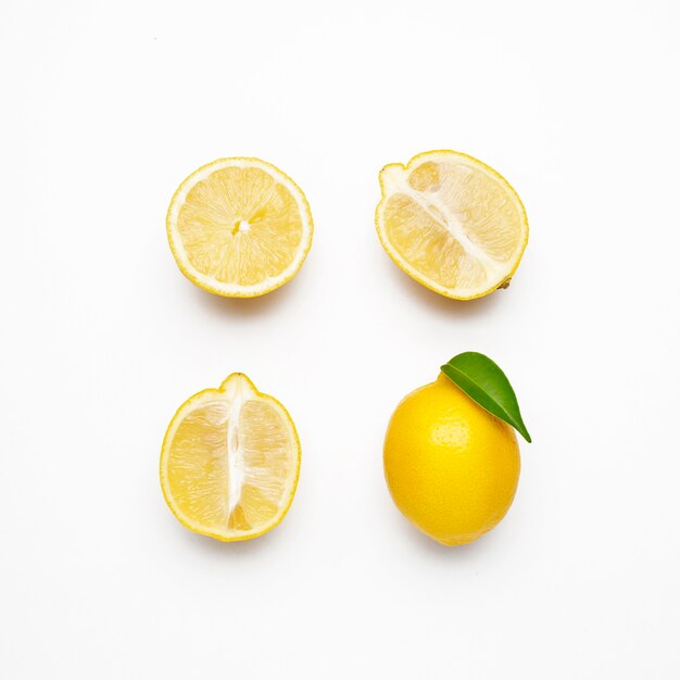 Elegante composición de juego de limones sobre una superficie blanca