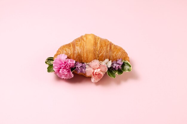 Elegante concepto de comida ecológica con flores en croissant