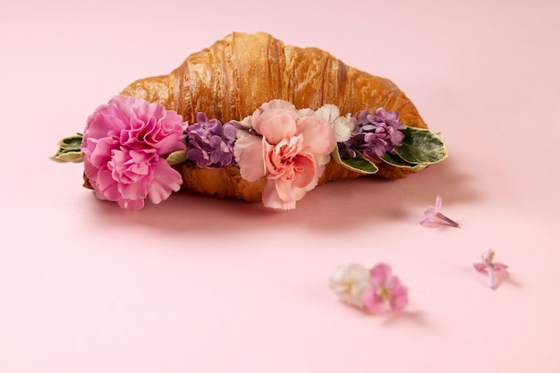 Elegante concepto de comida ecológica con flores en croissant