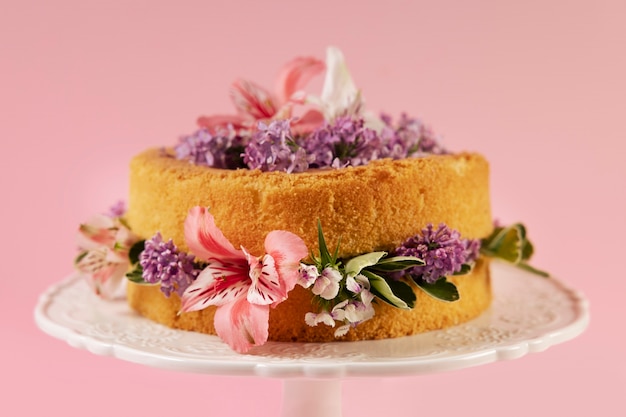 Foto gratuita elegante concepto de comida ecológica con flores en el pastel