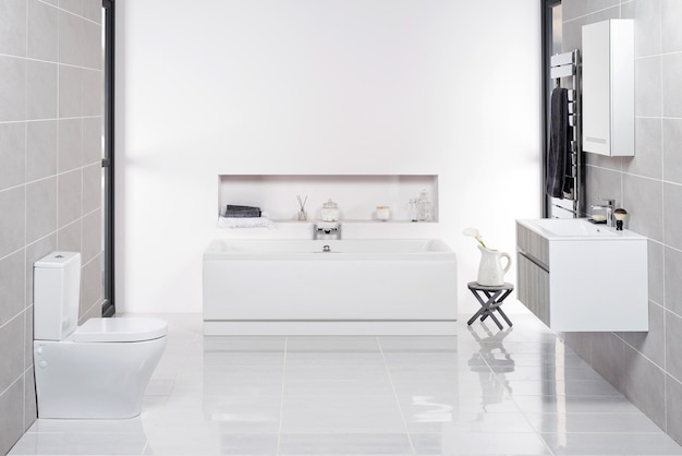 Elegante cuarto de baño minimalista con inodoro, bañera y lavabo blancos