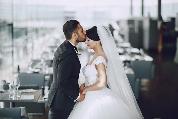 El elegante y elegante novio y su bella esposa en un restaurante