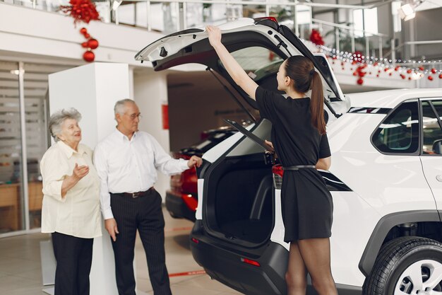 Elegante y elegante pareja de ancianos en un salón del automóvil