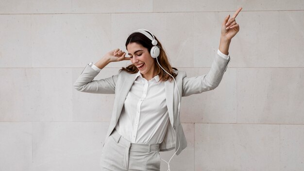 Elegante empresaria escuchando música en auriculares