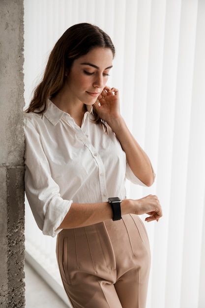 Foto gratuita elegante empresaria mirando su reloj inteligente