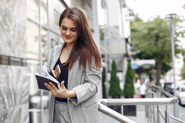 Elegante empresaria que trabaja en una ciudad y usa el cuaderno